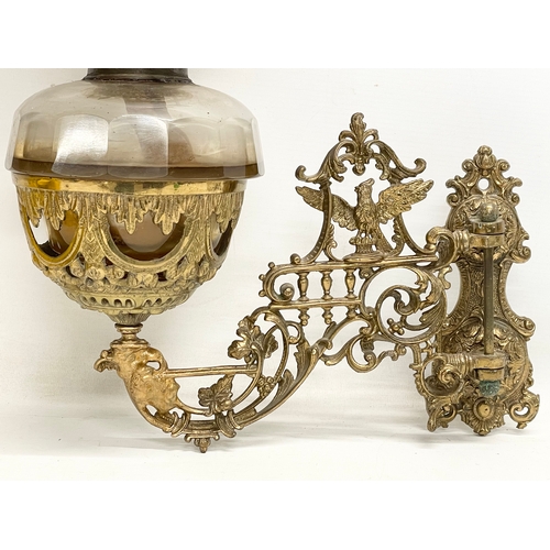 123 - A Victorian ornate brass wall handing double burner oil lamp with later shade. 36x54cm