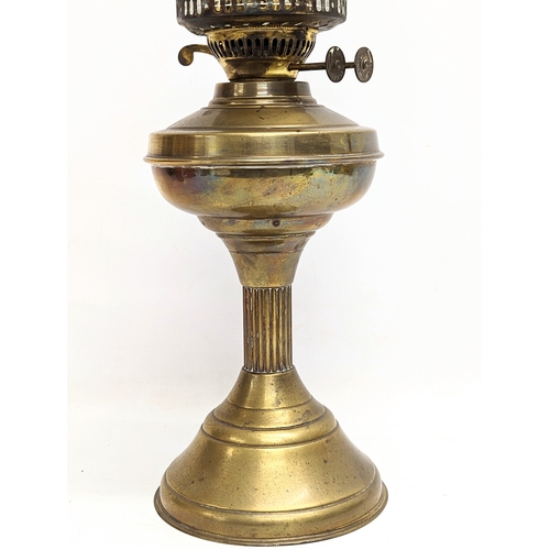 127 - An early 20th century brass double burner oil lamp with glass shade and funnel. 55cm