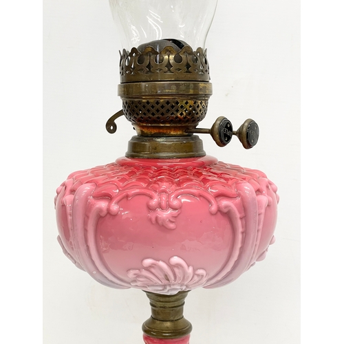 11 - A tall Victorian ornate pottery and brass double burner oil lamp. 67cm