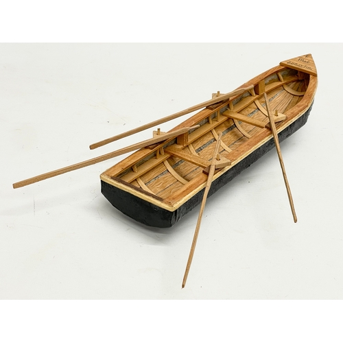 144 - An Irish hand made Currach model in box. Made in Connemara. Boat measures 31cm.