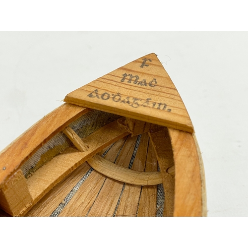 144 - An Irish hand made Currach model in box. Made in Connemara. Boat measures 31cm.