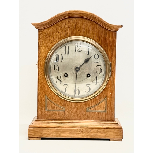 328 - An early 20th century oak cased mantle clock. 1900-1920. With key and pendulum. 24x15x32.5cm