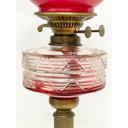 94 - A late Victorian brass double burner oil lamp, with later shade. 1900. 53cm