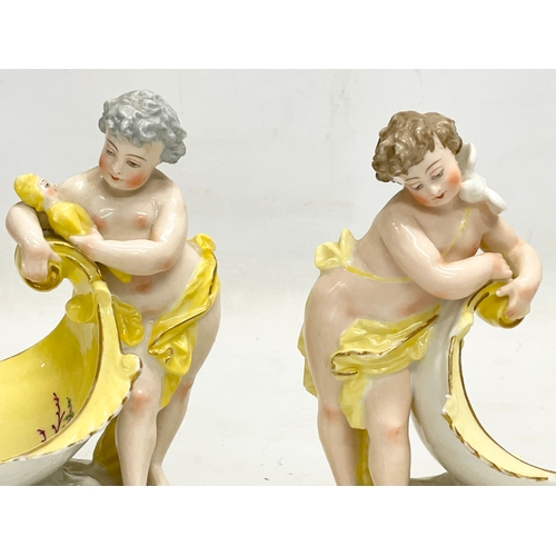 97 - A pair of late 19th/early 20th century German porcelain cherub stands. 13x16.5cm