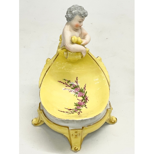 97 - A pair of late 19th/early 20th century German porcelain cherub stands. 13x16.5cm