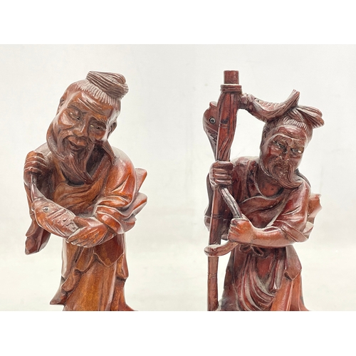 168 - A pair of vintage Chinese teak fisherman figures. 21cm.