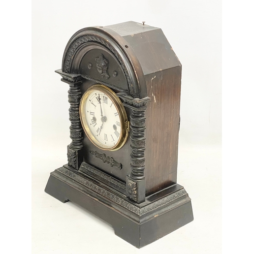 297 - A late 19th century oak cased mantle clock. With pendulum. 28x15x35cm