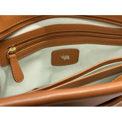 555 - A ladies leather handbag by Radley with cover.