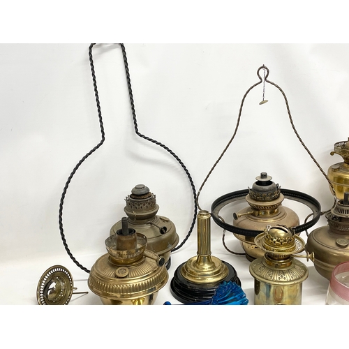 60 - A quantity of 19th and early 20th century oil lamps, shades oil lamp parts.