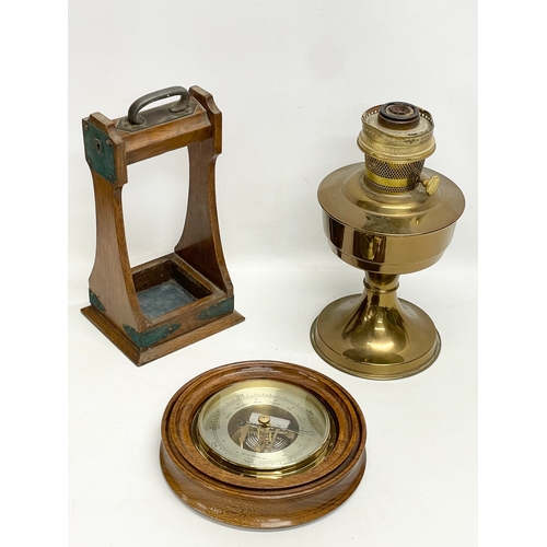 353 - A sundry lot. Including an Edwardian oak tantalus. An Aladdin brass oil lamp and a barometer.