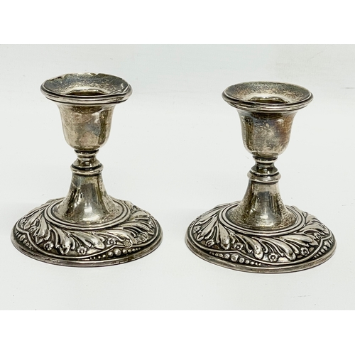 572 - A pair of sterling silver candlesticks. 7x7.5cm