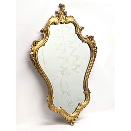 380 - An 18th century style Rococo ornate gilt framed mirror. 58x94cm