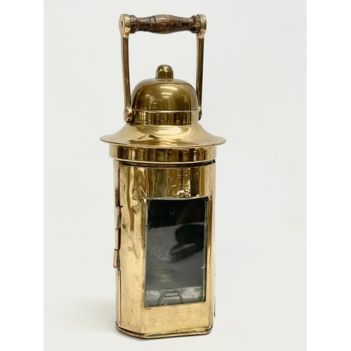 323 - A brass ships binnacle lamp. Stamped L.S Co LTD. 10x26cm including handle.