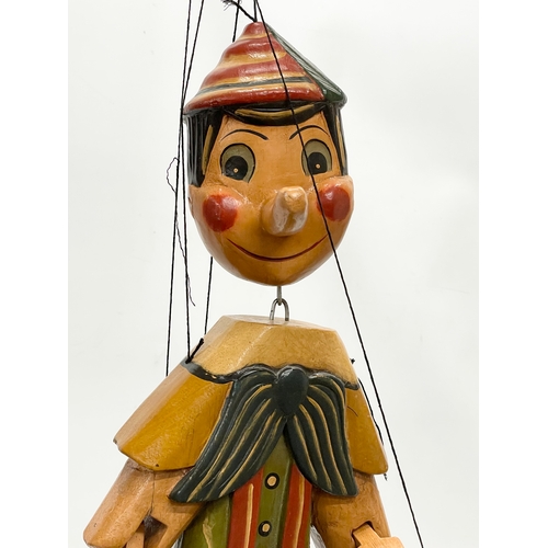 496 - A large vintage wooden Pinocchio puppet 65cm.