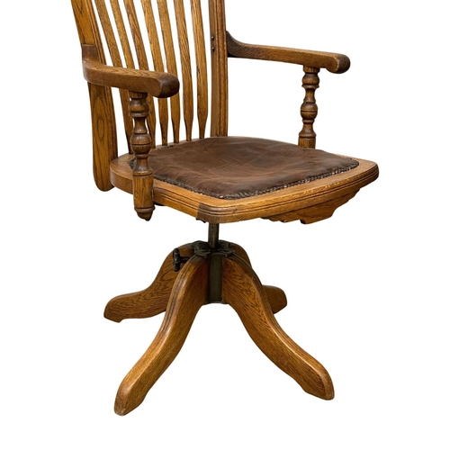 1015 - A late 19th century high back oak swivel desk chair. Dated from 1895.