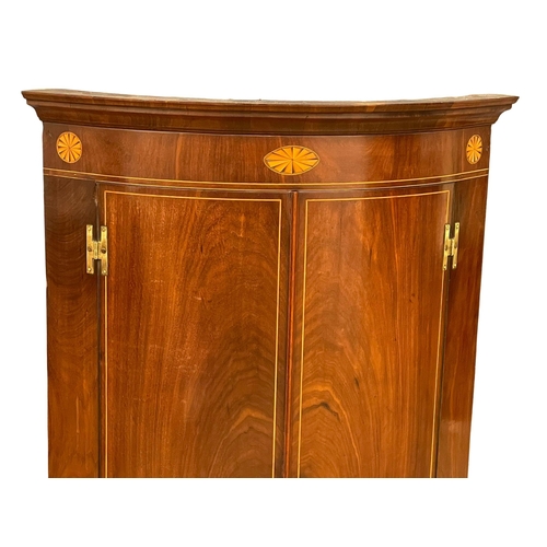 1017 - A late 19th century George III style inlaid mahogany wall hanging corner cabinet with fitted shelves... 