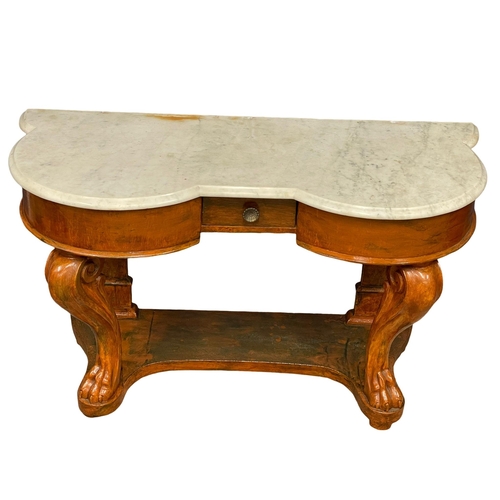 1042 - A Victorian mahogany marble top side table on lion paw feet.  121x50x73cm