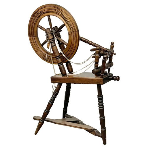 378 - A vintage spinning wheel. 70x104cm