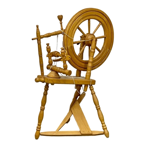 379 - A vintage spinning wheel. 70x104cm