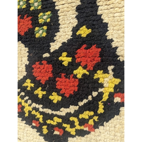 649 - A vintage wool work wall hanging. 62.5x142cm