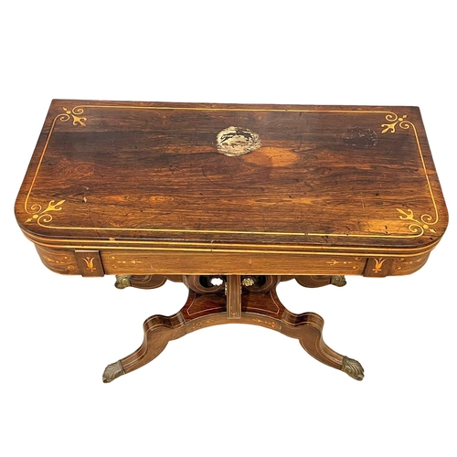 812 - An excellent quality Regency inlaid rosewood turnover games table with brass rosette mounts. Circa 1... 