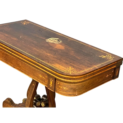 812 - An excellent quality Regency inlaid rosewood turnover games table with brass rosette mounts. Circa 1... 