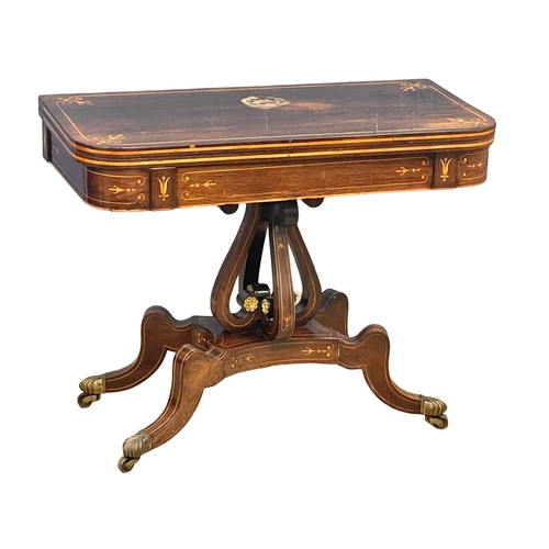 812 - An excellent quality Regency inlaid rosewood turnover games table with brass rosette mounts. Circa 1... 