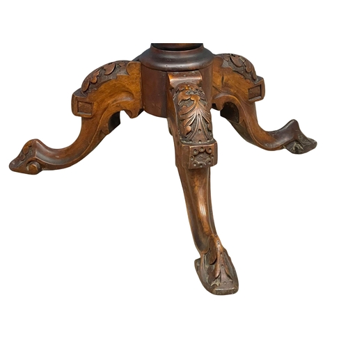 915 - A Victorian carved Walnut pedestal occasional table. 52x75cm