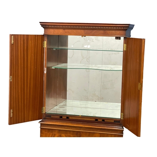 949 - A Georgian style flamed mahogany cocktail cabinet. 73x42x155cm