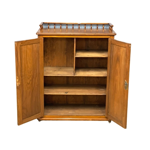 956 - A Victorian Walnut storage cabinet with interior shelves and gallery. 90x43x115cm