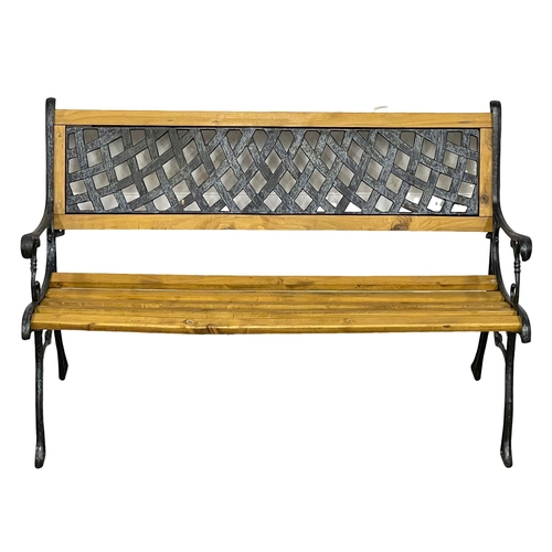 977 - A cast iron garden bench with wooden straps. 122cm