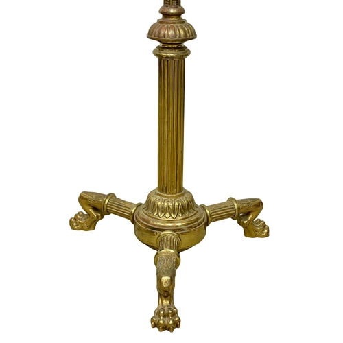 849 - A large Victorian brass candle stand on lion paw feet