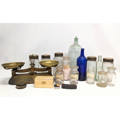 770 - A sundry lot of 19th / 20th century glass bottles and jars, with a set of brass Avery scales.