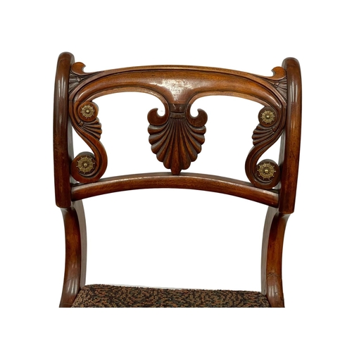 1075 - A pair of Regency mahogany side chairs on sabre legs. Circa 1810.