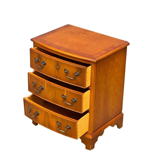 1099 - A small Georgian style inlaid yew wood bow front chest of drawers. 51x49x62cm