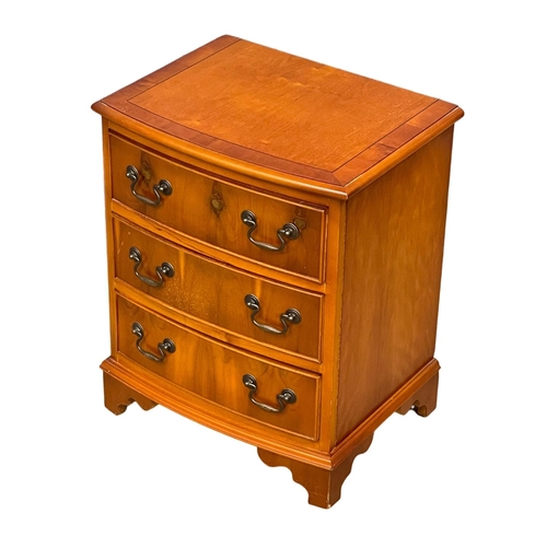 1099 - A small Georgian style inlaid yew wood bow front chest of drawers. 51x49x62cm