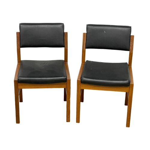 1074 - A pair of good quality Mid Century teak desk chairs with black vinyl seats and backs