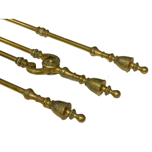 781 - A set of early 20th century brass fire andirons and tools.