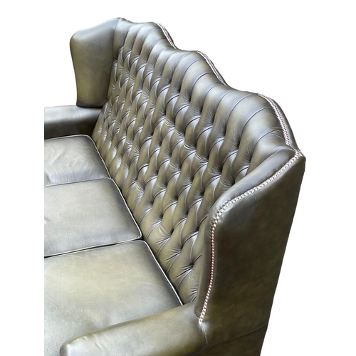 1102 - A deep button leather wingback 3 seater sofa. 180cm