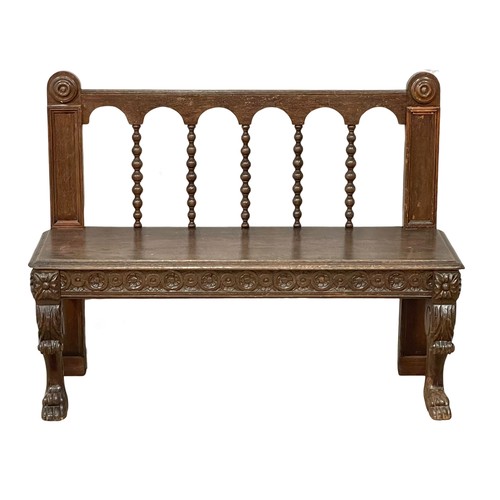 1033 - A Victorian carved oak hall bench on lion paw feet. Circa 1860. 123x40x94cm