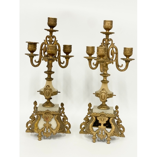 5 - A late 19th century French brass and onyx clock set. Clock measures 25x10x31cm. Candelabras 38.5cm.