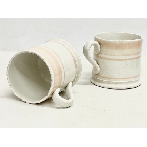 73 - A pair of Victorian glazed mugs. 14x10cm