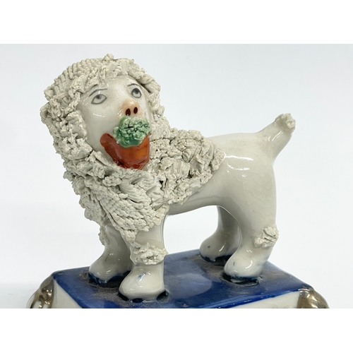 107 - A 19th century Staffordshire pottery poodle. 8x5x8cm