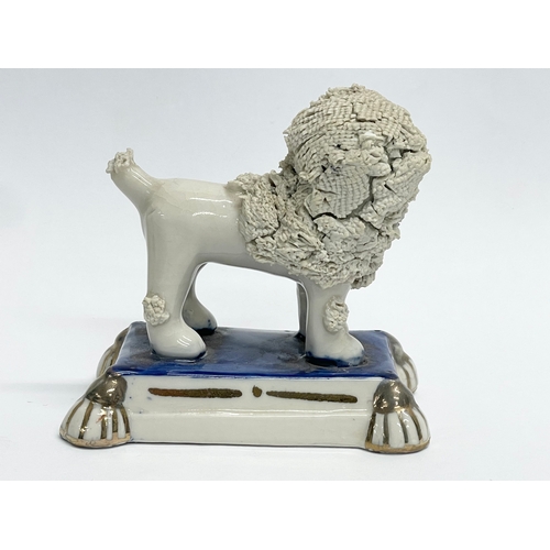 107 - A 19th century Staffordshire pottery poodle. 8x5x8cm