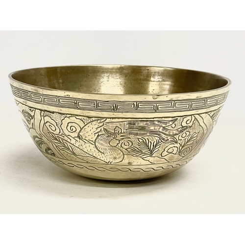 60 - A large early 20th century Chinese brass bowl on wooden stand. Bowl measures 24x11cm.