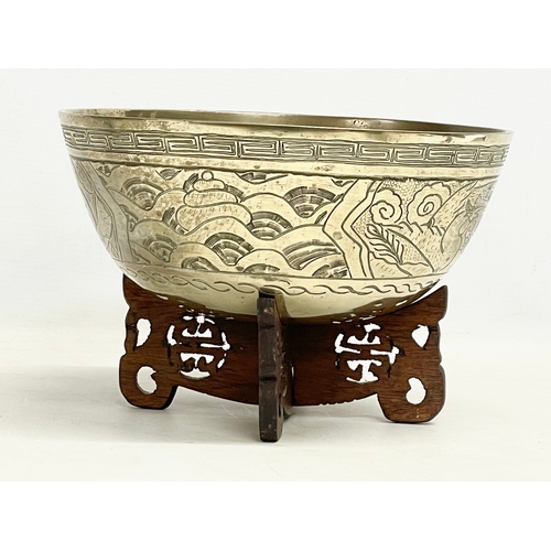 60 - A large early 20th century Chinese brass bowl on wooden stand. Bowl measures 24x11cm.