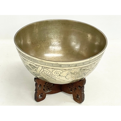 60 - A large early 20th century Chinese brass bowl on wooden stand. Bowl measures 24x11cm.