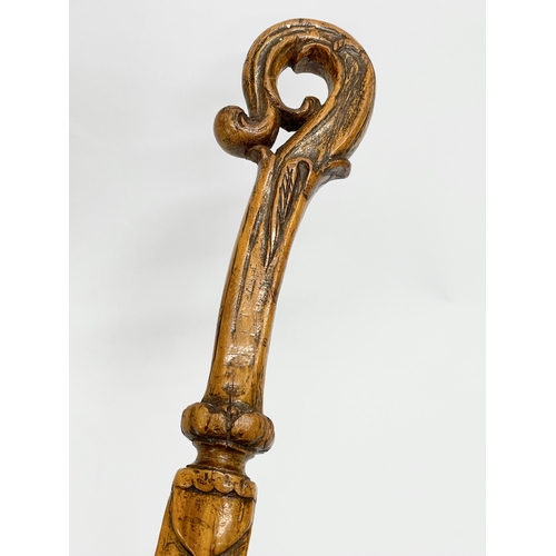 128 - A late 19th century North European carved fruitwood letter opener. 28cm