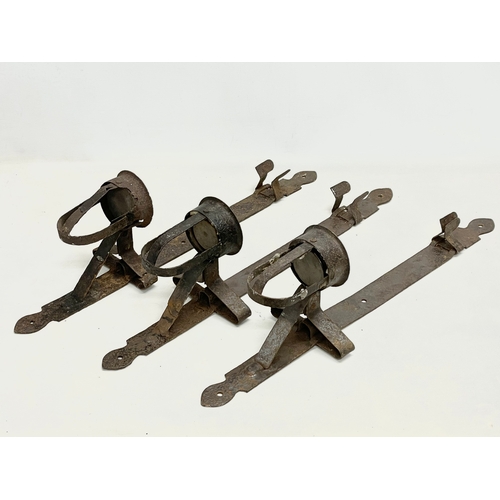 190 - 3 large 19th century iron wall hanging candleholders. 64cm