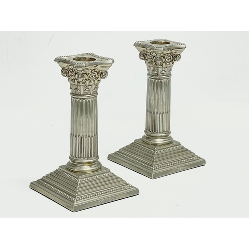 6 - A pair of Walker & Hall silver plated candlesticks with Corinthian style columns. 9x9x17cm